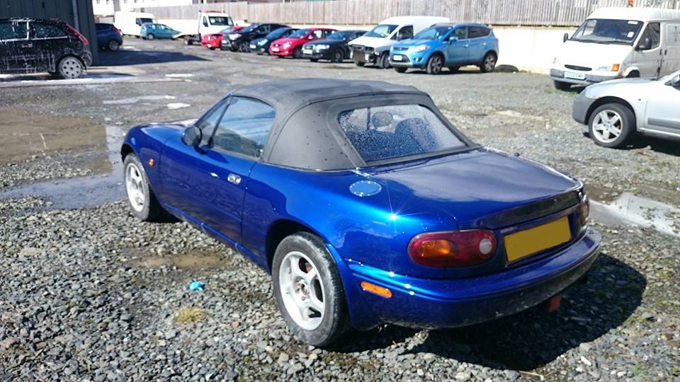 Blue Mazda MX5 MK1 with black hood